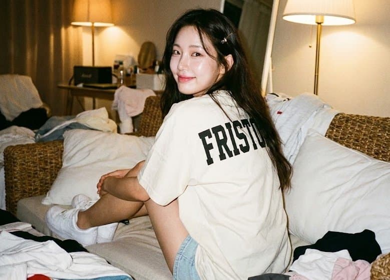 หญิงสาวนั่งบนโซฟาหวายโดยหันหลังให้ผู้ชม